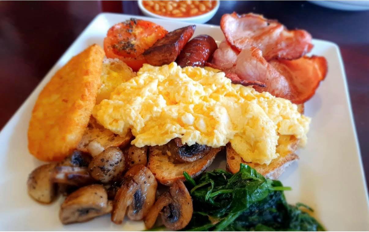 Big breakfast with eggs, greens and toast